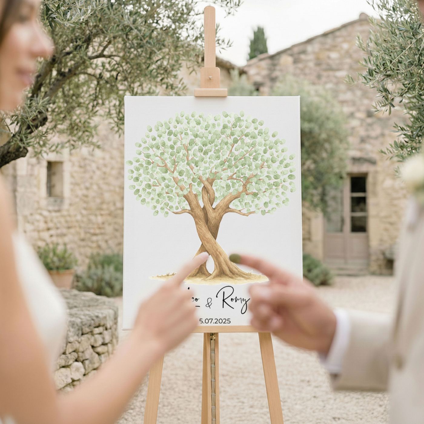 A couple pressing their fingerprints onto an olive-green tree canvas standing on an easel at their wedding